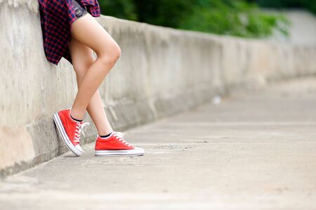 Focus on girl in red shoe on the concrete roadの写真素材