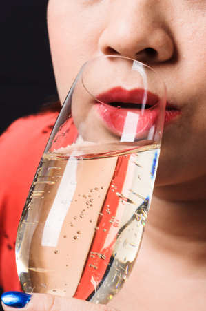 Close up red lip Asian young woman drinking champagneの写真素材