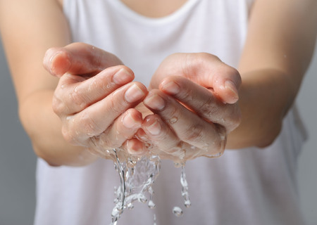 Close up on woman hand and water drop and blur body.の写真素材