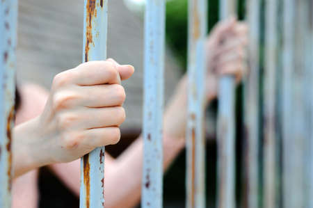 Close up thin focus on young woman hand in pink dress hole on rust iron bark in dark tone colorの写真素材