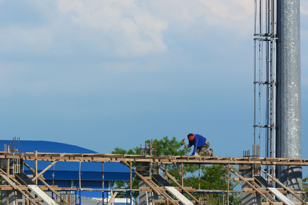Worker without helmet construct a white building under the day light
