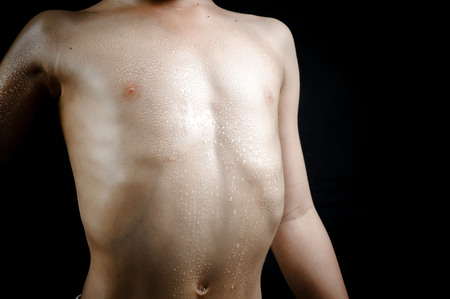 Close up on skin body muscle and sweat drop on young strong Asian boy body after heavy excercise