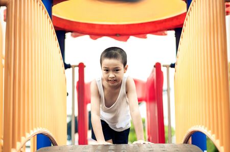 Young asian boy play on colorful play ground.