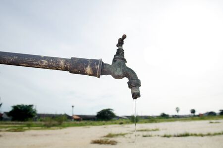 Close up old and dirty faucet on dry land