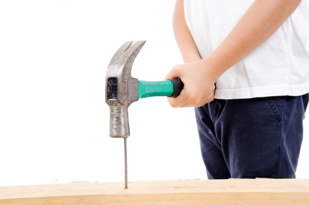 Little hand use hammer to hit the nail on the woodの写真素材