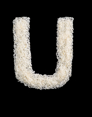 White rice grain alphabet letter isolated on black.の写真素材