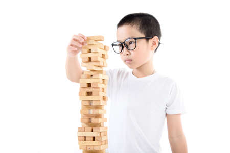 Young Asian boy try to build wooden block tower.の写真素材
