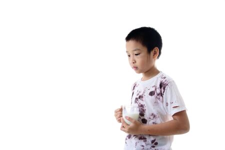 Young Asian boy carry a glass of milk looks happy. Health concept.の写真素材