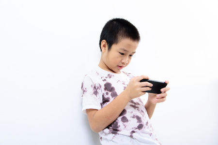 Younger Asian poor boy got a new smartphone and looks happy. Social network concept.の写真素材