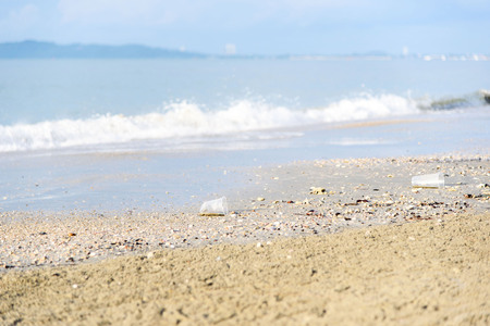 Many piece of garbage on the sand beace near the sea