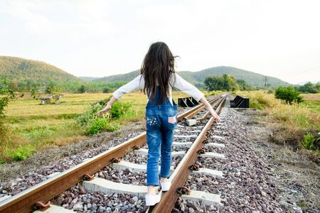 Young asian Thai girl, walking on the railway on the forest backgroundの写真素材