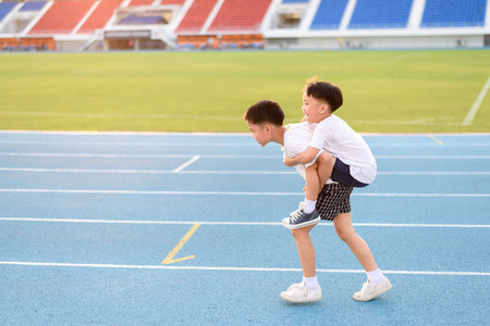 Boy help each other to run on the running track.の写真素材