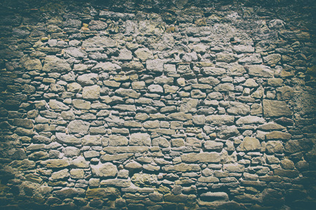 Vintage color tone and dark vignette effect. Contrast shadow of Antique of more than century aged of stone wall from the ancient city.の写真素材