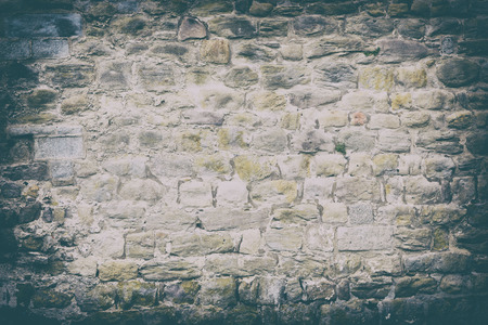Vintage color tone and vignett effect. Antique of more than century aged of stone wall from the ancient city.の写真素材
