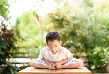 Young Thai boy practicing yoga in the park.Easy Pose.の写真素材