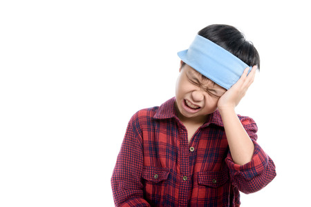 Young Thai boy headach by an illness and use ice cube to decrease temperature.の写真素材