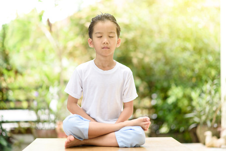 Young Thai boy practicing yoga in the park.Easy Pose.の写真素材