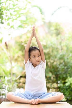 Young Thai boy practicing yoga in the park.Easy Pose.の写真素材