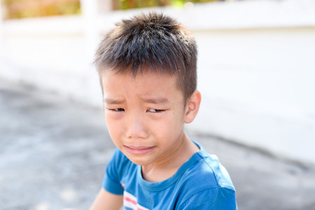 Young Asian Thai boy cry on the road after accident during sport.の写真素材
