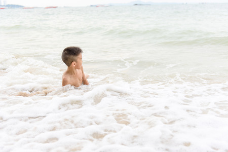 Young Asian Thai boy running on the beach during summerの写真素材