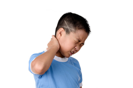 Young asian Thai boy has pain at his neck, isolated on white background.の写真素材
