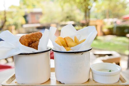 Selective focus at container of fries fish and ship with white creamの写真素材