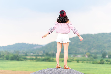 Vintage tone, Selective focus at young girl stand on the grey hill  that feel freedom and relax during summer.の写真素材