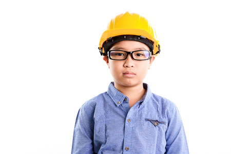 Young asian Thai boy in yellow safety helmet pretend to be engineering during construction area.