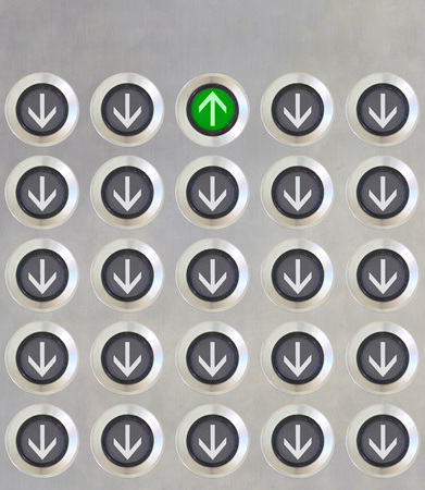 Elevator Button in different direction but only on button in green light point up on stanless plate. Correct direction and team working concept.の写真素材