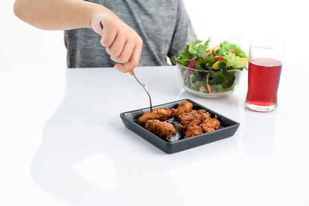 Young kid hand choose deep fry chicken instead of mix vegetable salad.の写真素材