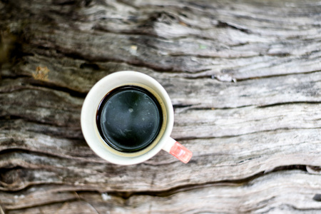 Selective focus at coffee in vitage coffee cup on white old wooden or timber table in a gardenの写真素材