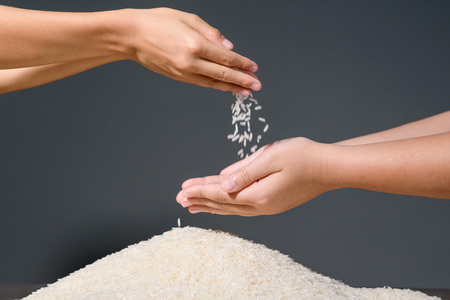Little hands of a kids poring rice on a bunch.の写真素材