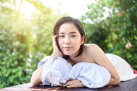 Selective focus at Young Asian woman face feel relax after oil massage at garden in spa resort.の写真素材
