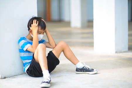 Young boy wearing a mask and feel uncomfortable from sick.の写真素材