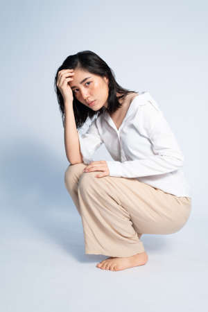Shooting studio portrait of young Asian Thai woman with white shirt on white background. Relax and mordern concept.の写真素材