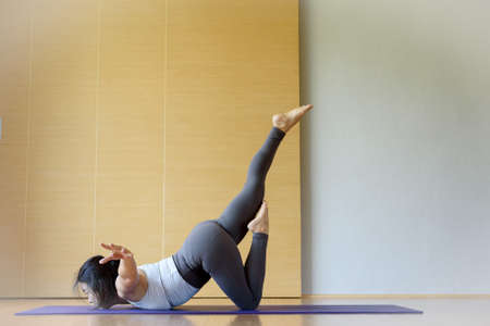 Young Asian Thai practice yoga at home studio