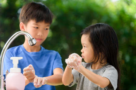 Selective focus at young boy and girl hand  wash hand to prevent germ and virus infection during...