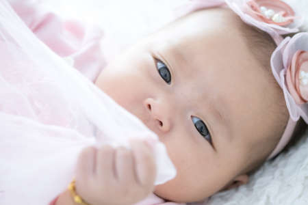 Portrait Happy Asian female baby on white bedの写真素材