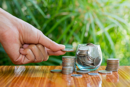 women hand put money coins to stack of coins. Business Growth concept.の写真素材