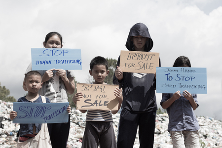 Standing childs holding a sign, anti-trafficking, stopping violent acts against children, stopping child labor.の写真素材