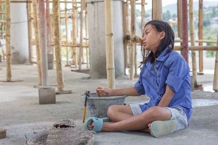 A child forced to work as construction worker. Violence children and trafficking concept. Anti-child labor, rights day on December 10.の写真素材