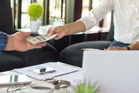 Businessmen are paying compensation to partners,  receiving dividends from investments.の写真素材