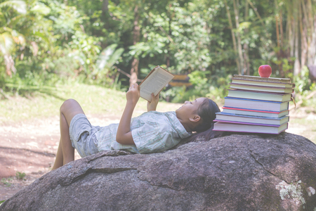 Children sitting reading a happy grill.natural background,educational and Scientific Conceptsの写真素材