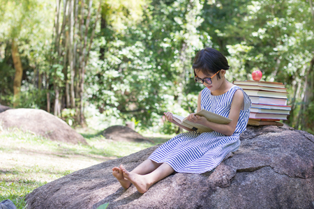 Children sitting reading a happy grill.natural background,educational and Scientific Conceptsの写真素材