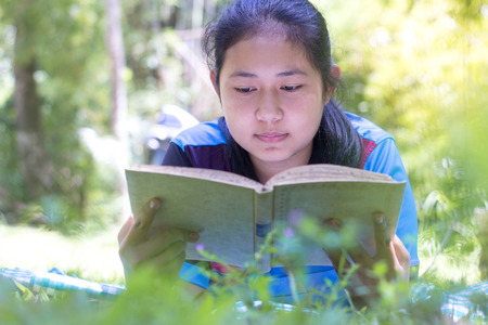 Children read the book next to the rocks, in the midst of nature,natural background,educational and Scientific Conceptsの写真素材