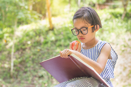Children  holding an apple ball reading a book,educational and Scientific Conceptsの写真素材