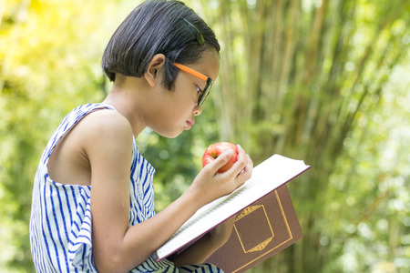 Children  holding an apple ball reading a book,educational and Scientific Conceptsの写真素材