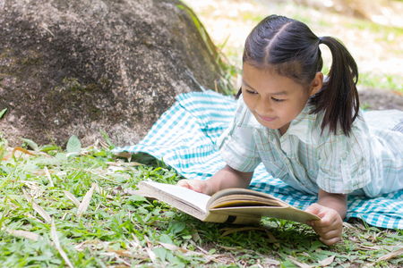 Children read the book next to the rocks, in the midst of nature,natural background,educational and Scientific Conceptsの写真素材