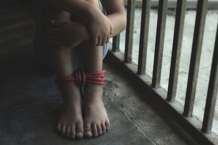 Kidnapped boy tied with rope and locked in a steel cage. stop abusing violence.concept for kidnapping, violence, terrified,  Human Rightsの写真素材