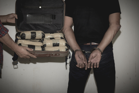 Drug traffickers were arrested along with their heroin. Police arrest drug trafficker with handcuffs. The concept of crime and drug addiction. 26 June, International Day Against Drug Abuse and Illicit Traffickingの写真素材